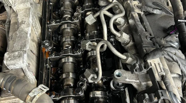 Diesel engine with the cam cover removed, showing both camshafts and the injector pipes