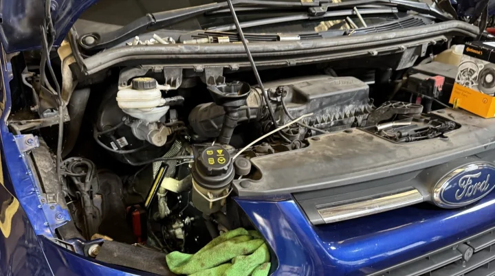 Ford van in the workshop with the bonnet open and the engine bay exposed